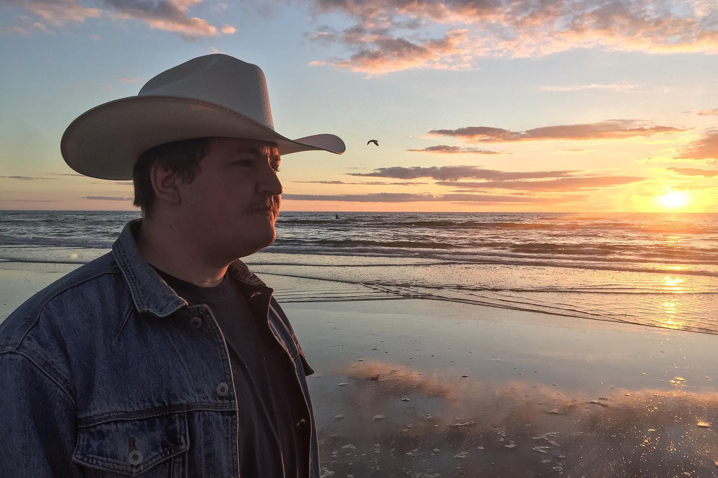 boy in cowboy hat at the beach