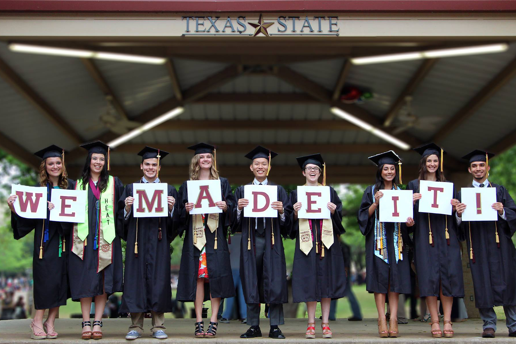 college graduates holding we did it sign